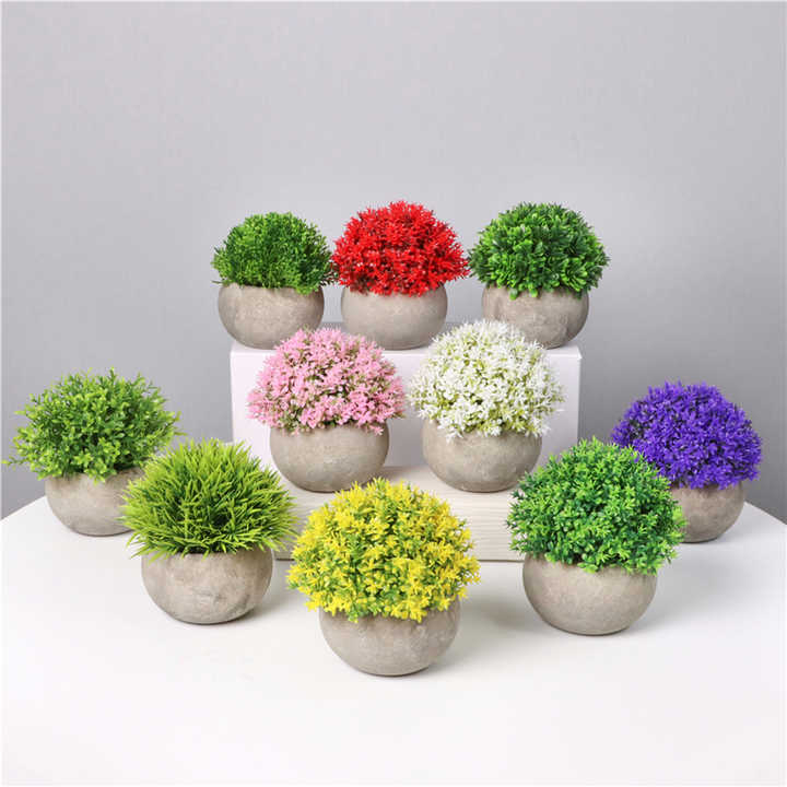 نباتات اصطناعية صغيرة في . Small artificial plants in plastic pots